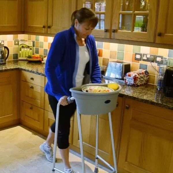 lady in a blue jacket pushing the caddy in the kitchen