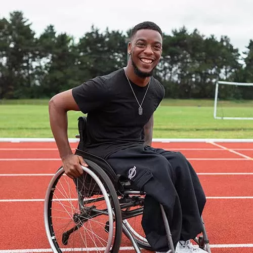 Bealies user, Shaun in his wheelchair on a sports track