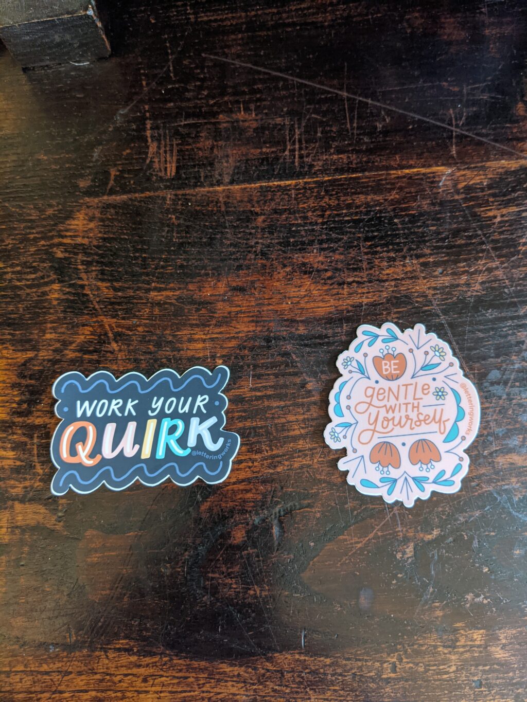 work your quirk sticker on a wooden table. Black cloud design with quirk written multi-coloured