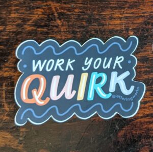 work your quirk sticker on a wooden table. Black cloud design with quirk written multi-coloured