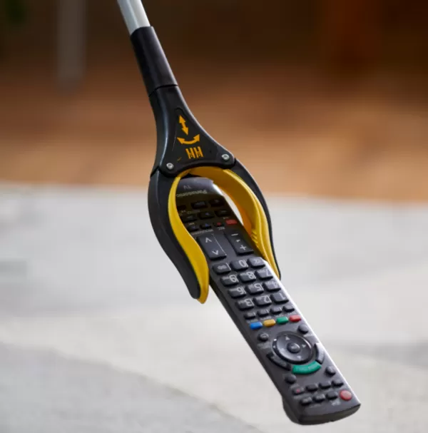 Arthigrip reacher grabber shown holding a remote control