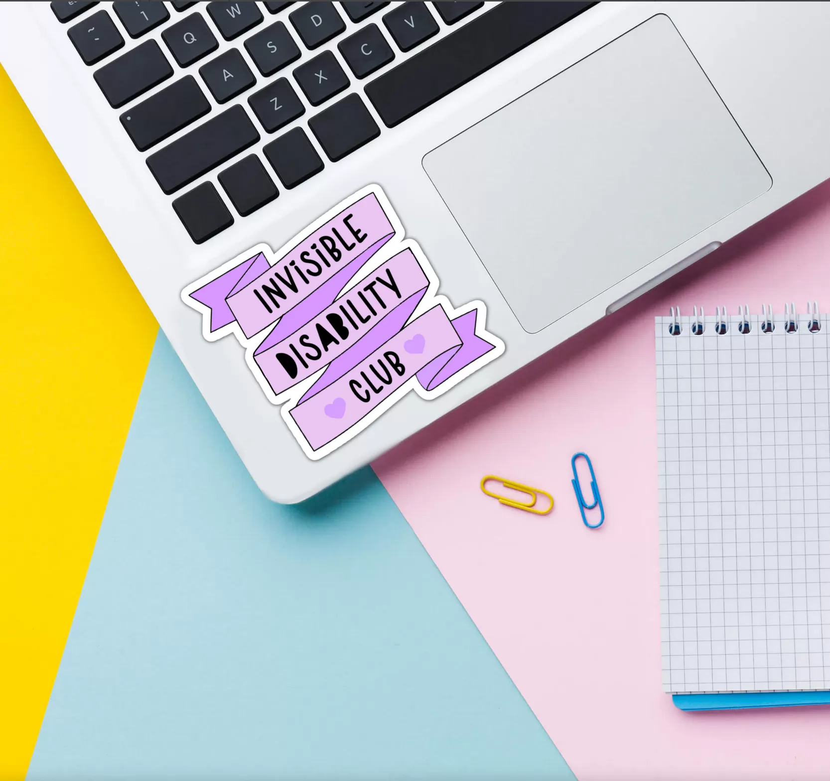 invisible disability club sticker stuck to a laptop