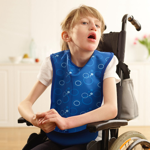Child in wheelchair wearing Junior tabard-style bib