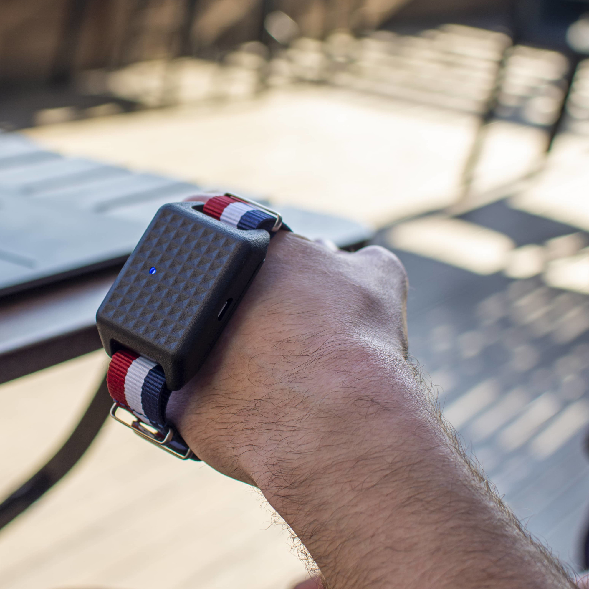 Hand with a watch-like strap and square tablet which is a wearable mouse