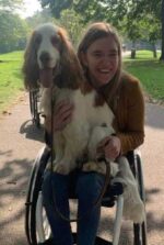 Georgia from Whizzkidz in a wheelchair holding a dog