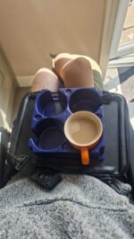 trabasack lap tray being used with a muggi to hold a red mug of coffee, James' amputated leg can also be seen, James uses these to adapt to life in a wheelchair