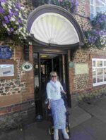 Clare outside the Fox Pub in Felpham. She is in the doorway under a half shell tile design.