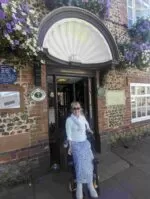 Clare outside the Fox Pub in Felpham. She is in the doorway under a half shell tile design.