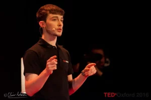 Chris Williams of Tiggo Care at a TED Talk, young clean shaven man with short brown hair in a t-shirt