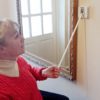 The light switch extender being used by a wheelchair user