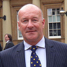 An older balding man in a suit and tie