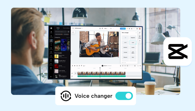 A person sits at a desk viewing CapCut on a large monitor. The screen shows a video editing project with a man playing guitar and the voice changer tool panel open. A toggle labeled “Voice changer” is switched on. The CapCut logo appears on the right.
