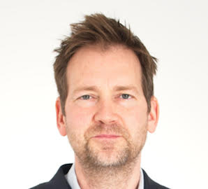 Tim halloram head bio photo a white man in his thirties with short hair and stubble. Tim is an expert on bariatric stairlifts for narrow and difficult spaces.