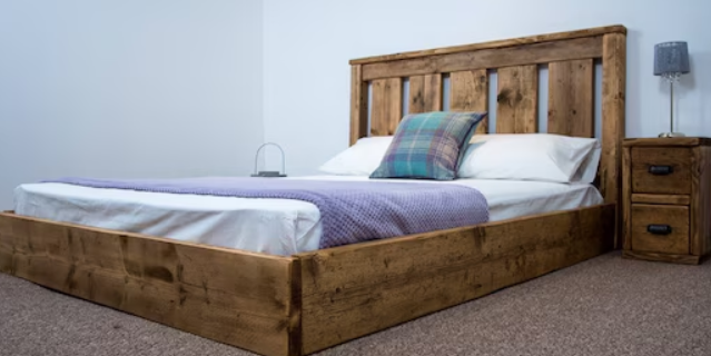 Bed with high wooden sides and headboard, making it hard to tuck in fitted sheets.