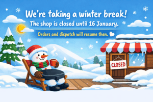 Illustration of a smiling snowman relaxing in a deck chair with a black Trabasack-style lap tray on their lap, holding a hot drink, beside a snowy shop with a “Closed” sign and text saying the shop is closed until 16 January.