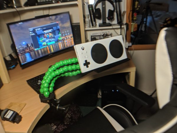 Xbox Adaptive Controller mounted to a desk using a green MERU Flexzi arm for accessible gaming.