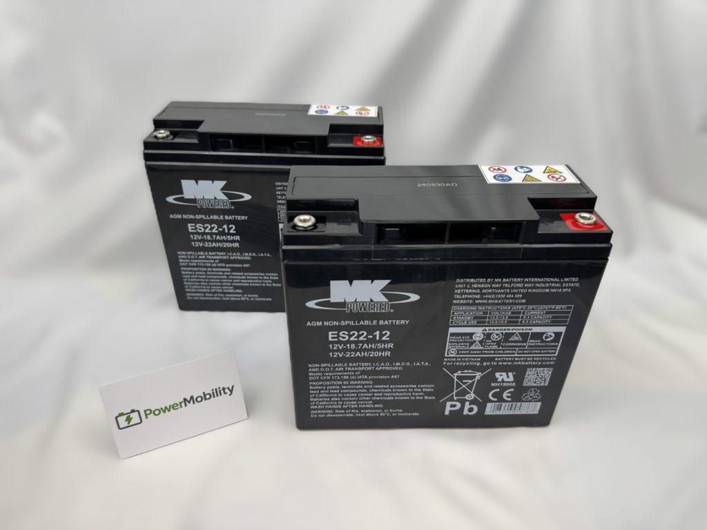Two black AGM mobility scooter batteries (ES22-12) with red and black terminals, beside a PowerMobility card.