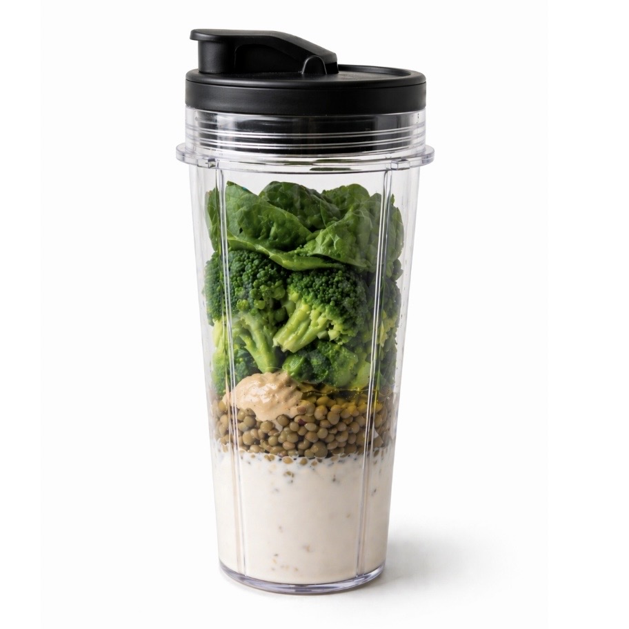 Blender cup filled with vegetables, lentils and other ingredients ready to make a blended tube feeding meal.